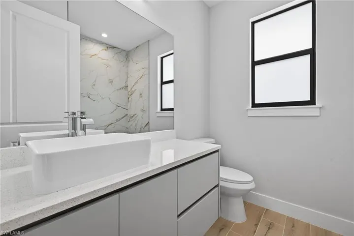 Modern vanity featuring a rectangular vessel sink with chrome faucet, quartz-finish countertop, and integrated gray cabinetry