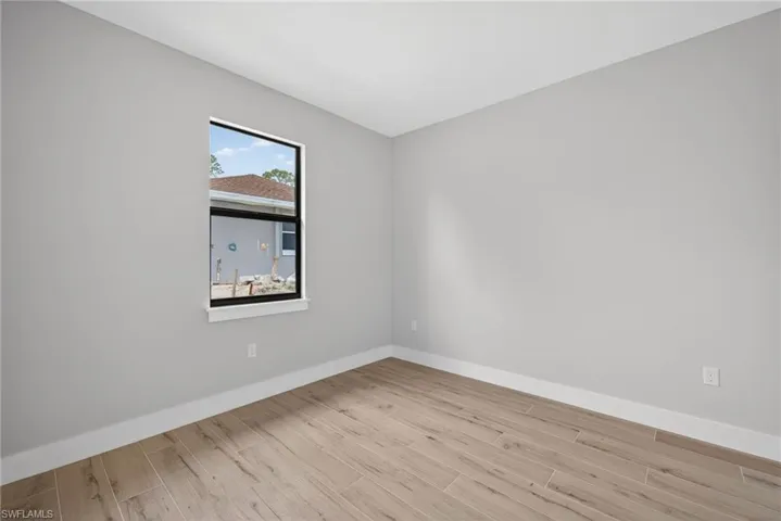 Interior space featuring wood-finish flooring, light gray wall paint, and white baseboards