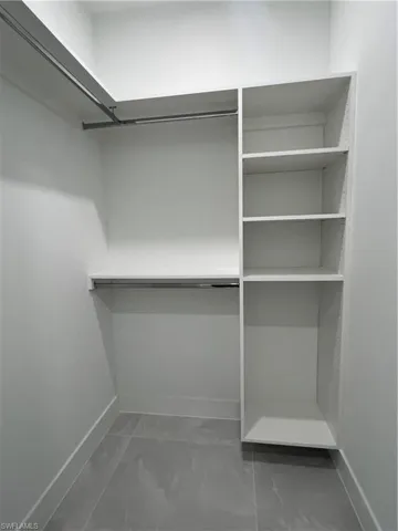 Walk in closet featuring marble finish flooring