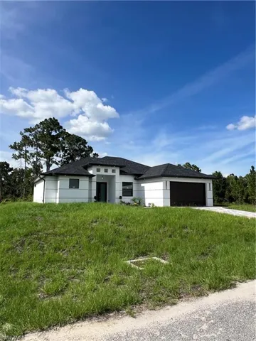 Prairie-style house with an attached garage, concrete driveway, and roof with shingles
