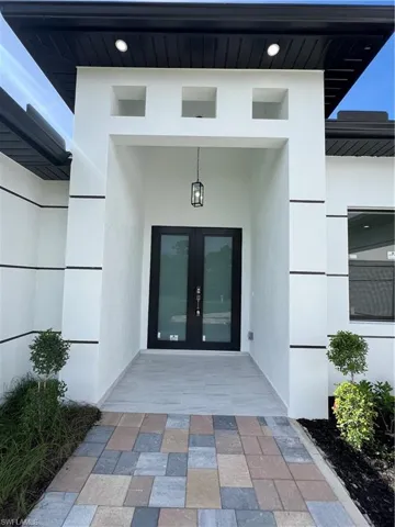 Entrance to property featuring french doors and stucco siding