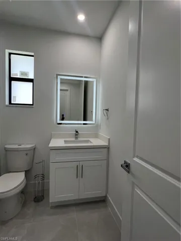 Bathroom featuring vanity and marble look tiles