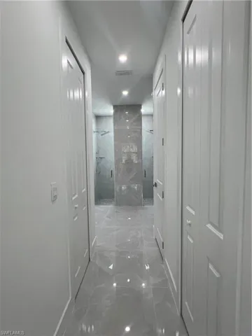Hallway with marble tiled flooring and baseboards