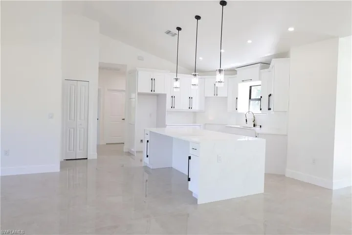 View of front of home with stucco siding, a front lawn, roof with shingles, a garage, and driveway