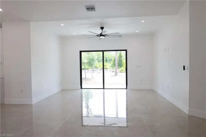Kitchen featuring light stone countertops, decorative light fixtures, white cabinets, and recessed lighting