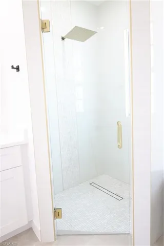 Bathroom featuring vanity, a shower stall, light tile patterned floors, and recessed lighting