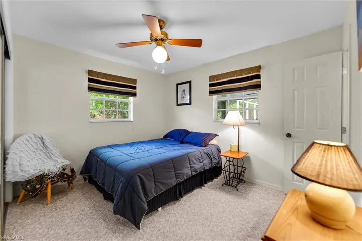 Carpeted bedroom featuring a ceiling fan and baseboards