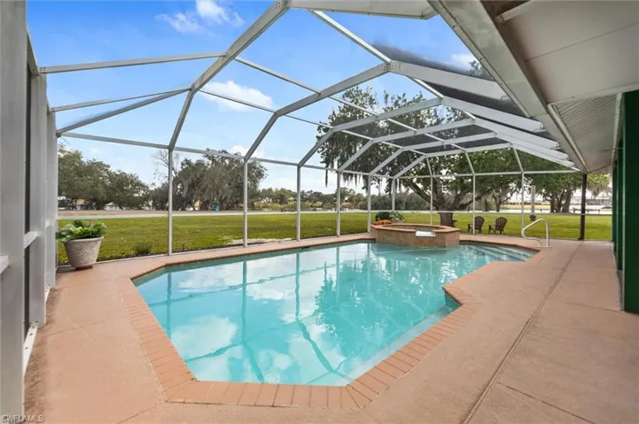Integrated pool / hot tub with a lawn, a lanai, a sunroom, and a patio