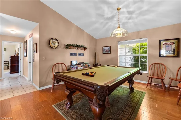 Recreation room with vaulted ceiling, light wood floors, and billiards