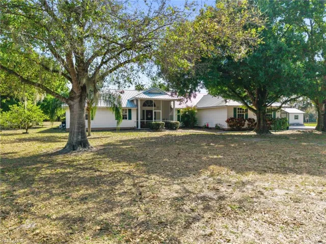 View of front of house featuring a metal roof and a front lawn