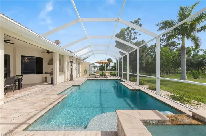 View of swimming pool with a lanai, a yard, ceiling fan, and a patio area