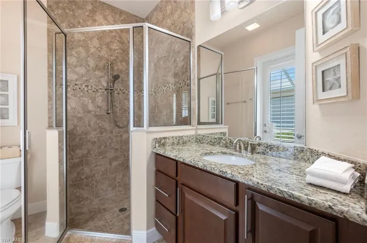 Bathroom featuring vanity, toilet, and walk in shower