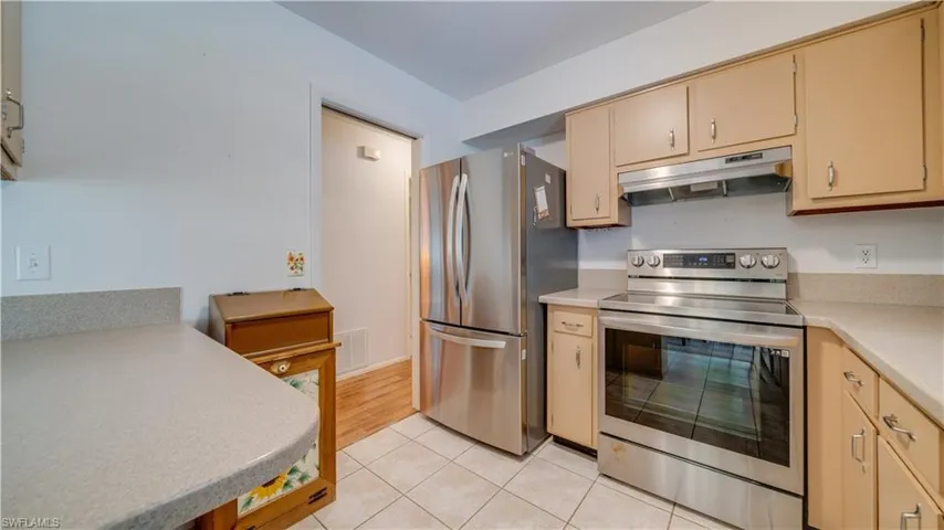 Kitchen featuring stainless steel appliances and light tile patterned flooring