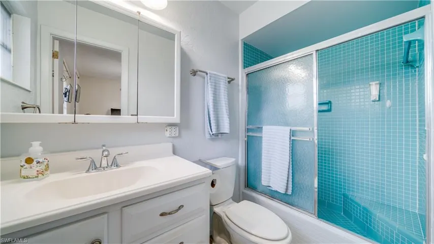 Full bathroom featuring vanity, toilet, and enclosed tub / shower combo