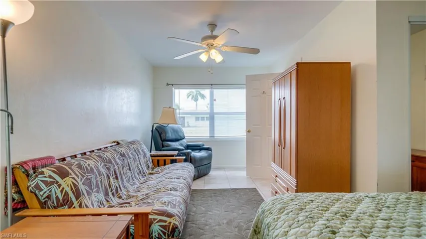 Bedroom with ceiling fan and light tile patterned floors
