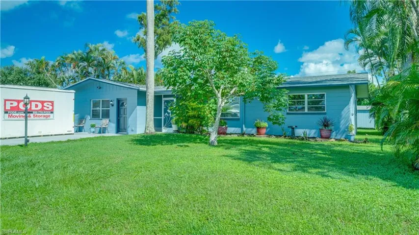 Rear view of property with a yard