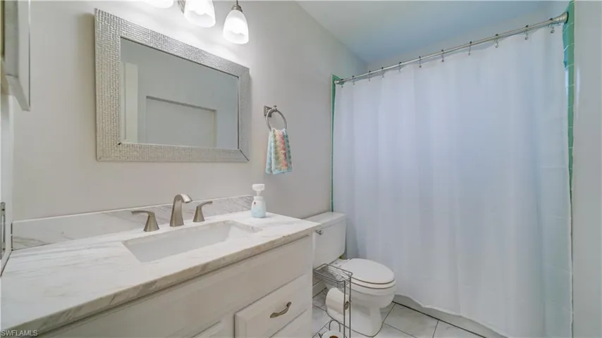 Bathroom featuring walk in shower, toilet, and vanity
