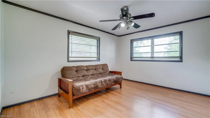 Living area with ceiling fan, ornamental molding, and light hardwood / wood-style flooring