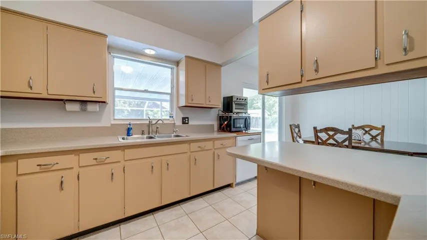 Kitchen featuring dishwasher, sink, and light tile patterned floors