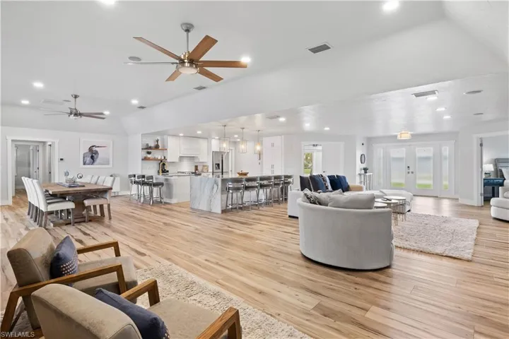 Living room featuring light wood-style floors, recessed lighting, and visible vents