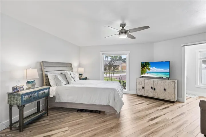 Bedroom featuring ceiling fan, baseboards, access to outside, and wood finished floors
