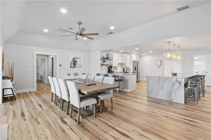 Dining space with light wood-style floors, recessed lighting, visible vents, and baseboards