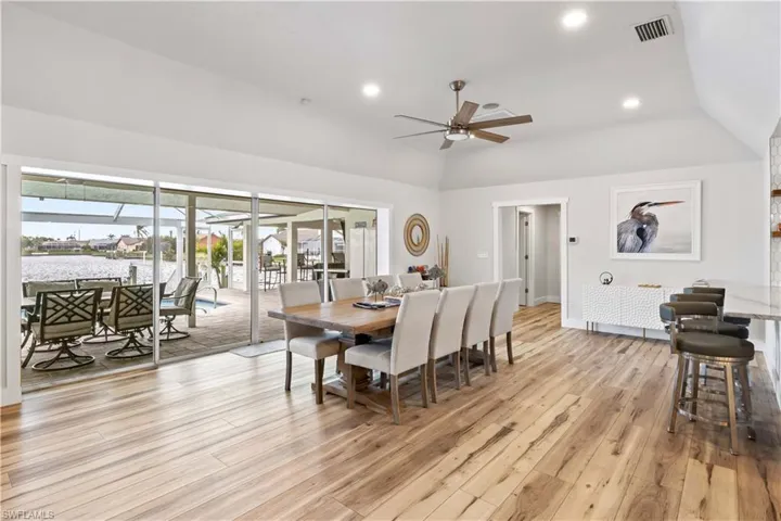 Dining space featuring lofted ceiling, light wood-style flooring, visible vents, and recessed lighting
