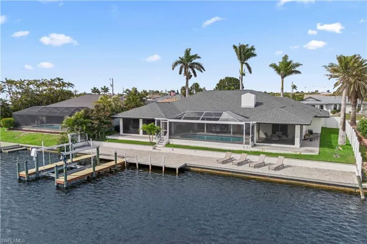 Back of house with an outdoor pool, a patio, a fenced backyard, a water view, and a lanai