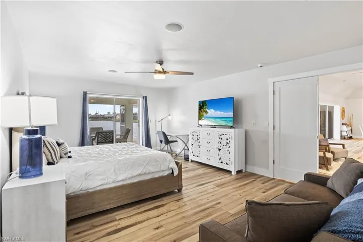Bedroom with access to exterior, baseboards, ceiling fan, and light wood finished floors