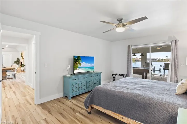Bedroom featuring baseboards, light wood-style floors, a ceiling fan, and access to exterior