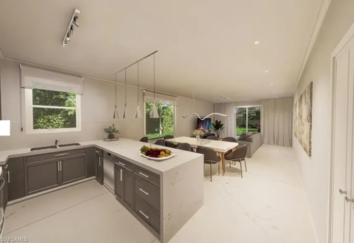 Kitchen featuring a peninsula, healthy amount of natural light, open floor plan, and light stone countertops