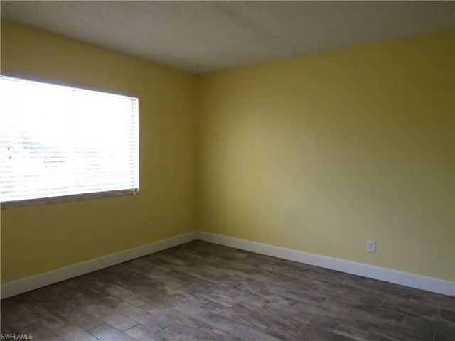 Spare room featuring dark hardwood / wood-style flooring and a textured ceiling