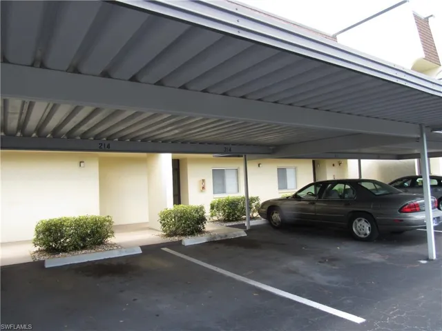 View of parking / parking lot with a carport