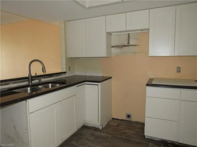 Kitchen featuring white cabinetry, dark hardwood / wood-style flooring, and sink