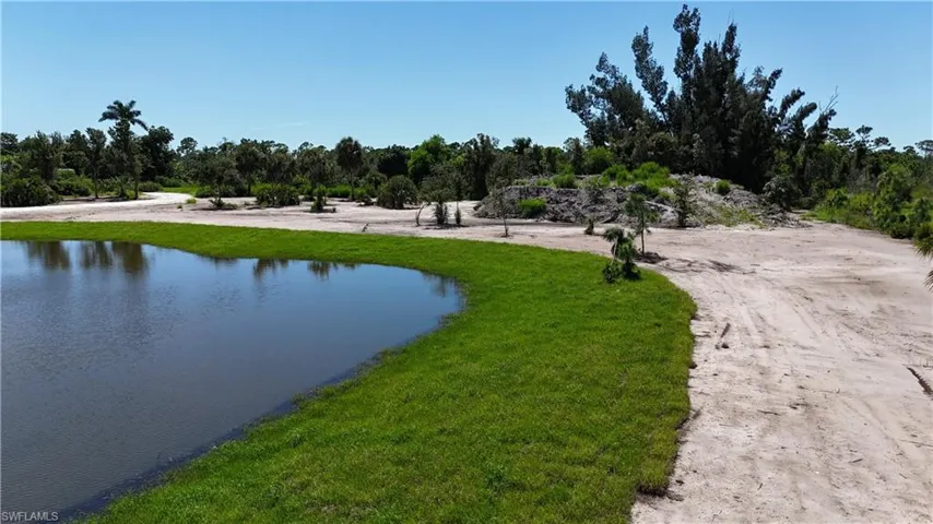 Surrounding community with a water view and a lawn