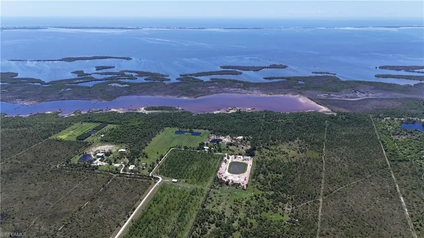Aerial view of sparsely populated area featuring a large body of water and farmland
