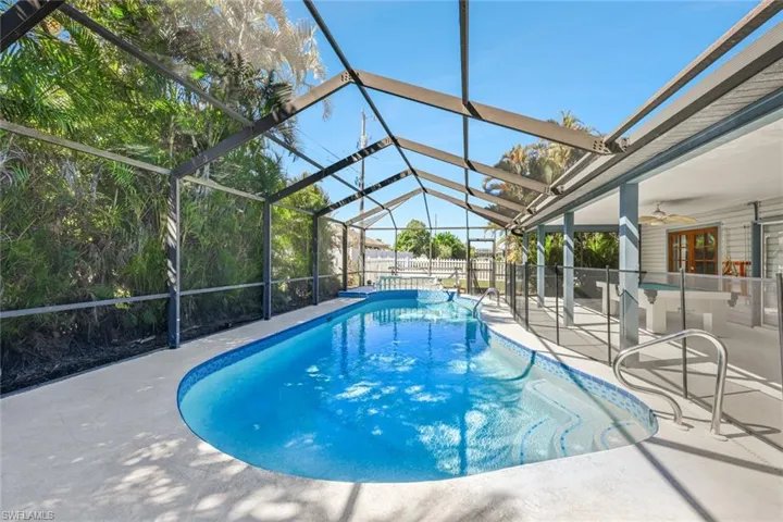 View of swimming pool featuring a sunroom, patio surround, and a lanai