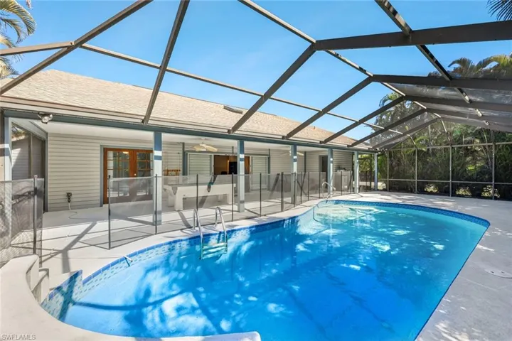 Outdoor pool featuring glass enclosure, a sunroom, and a patio area