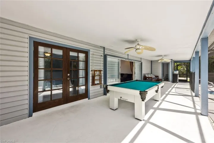 Recreation room featuring french doors, ceiling fan, and concrete flooring