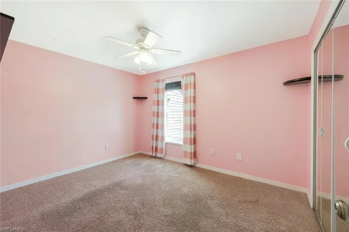 Empty room with light colored carpet and ceiling fan