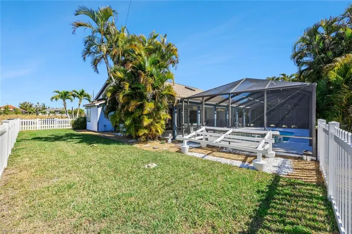 Fenced backyard featuring a sunroom, a pool, and glass enclosure