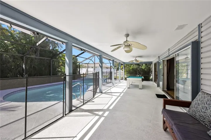 Swimming pool with a patio area, a sunroom, and glass enclosure