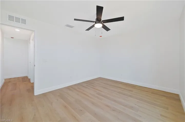 Unfurnished room featuring a ceiling fan, baseboards, and light wood-style floors