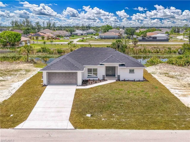 View of front of property featuring a garage, stucco siding, concrete driveway, a residential view, and a front lawn