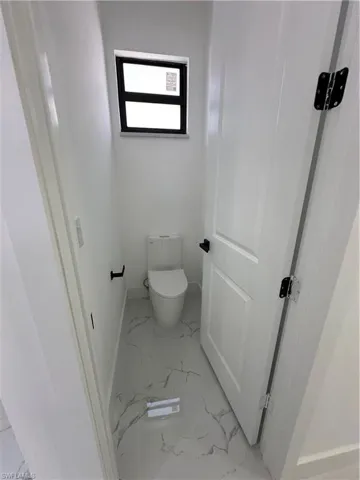 Bathroom featuring baseboards and light marble finish flooring