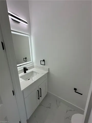 Half bathroom featuring vanity and baseboards