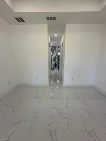 Empty room featuring recessed lighting and light marble finish floors
