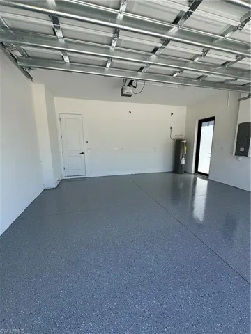 Garage featuring electric panel and water heater