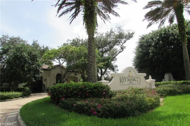 "Key Marco" stone entry monument surrounded by mature landscaping