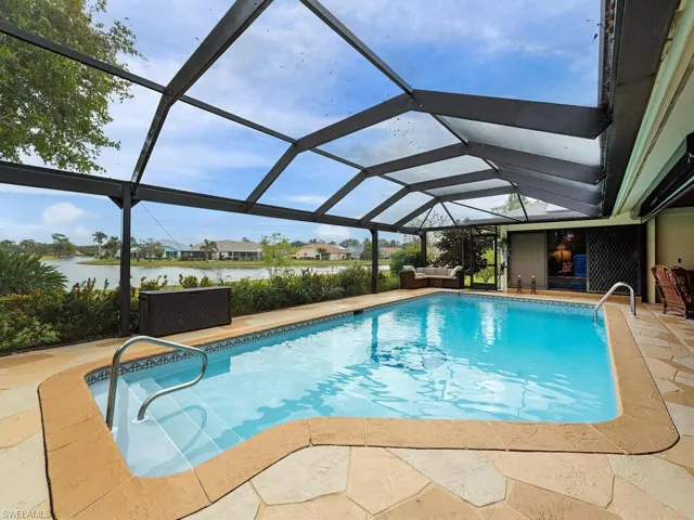 View of swimming pool with an outdoor living space, a patio, a water view, and a lanai